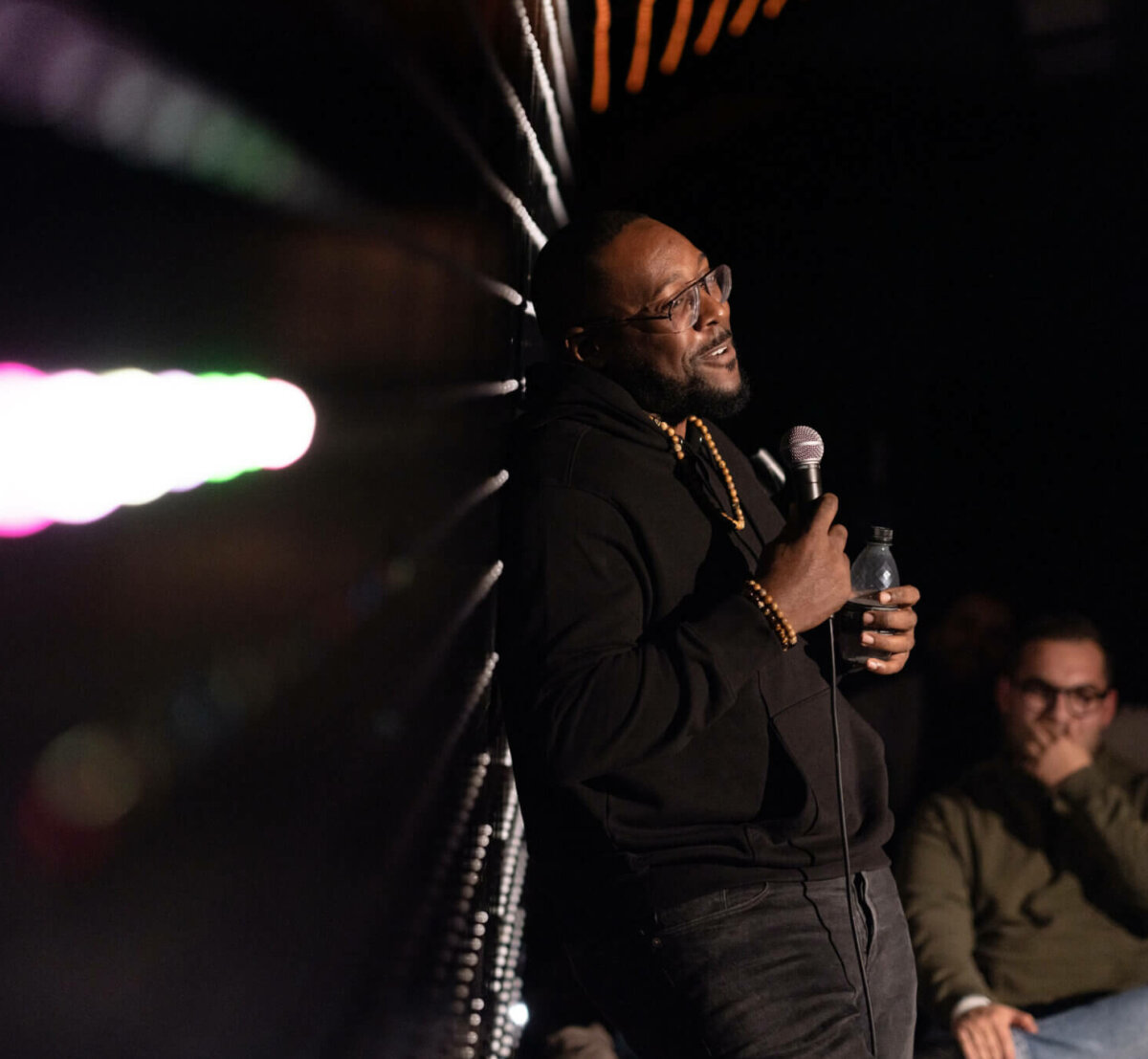 Comedian Aurie Styla leans on the LED wall at Big Belly Comedy Club London