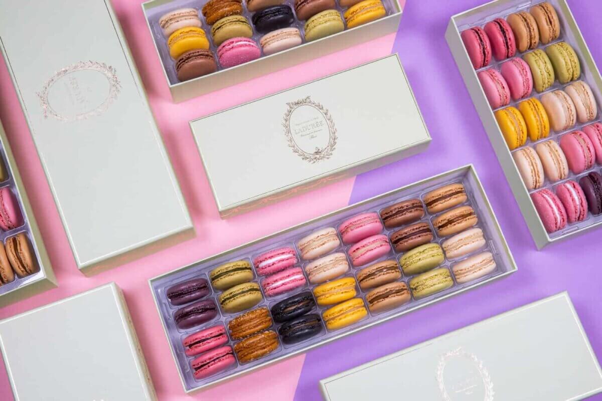 Macarons in boxes on a colorful background.