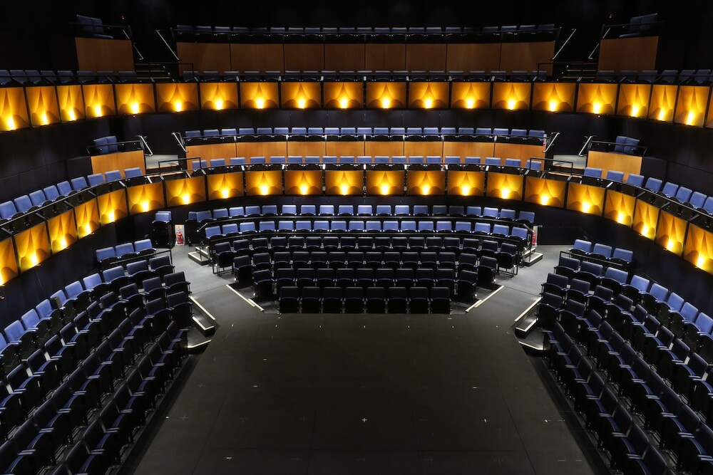 Large auditorium, blue seats.