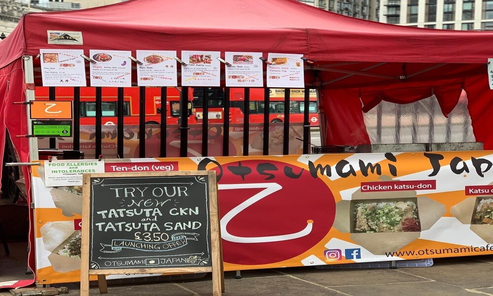 A street food stall with a sign on it.