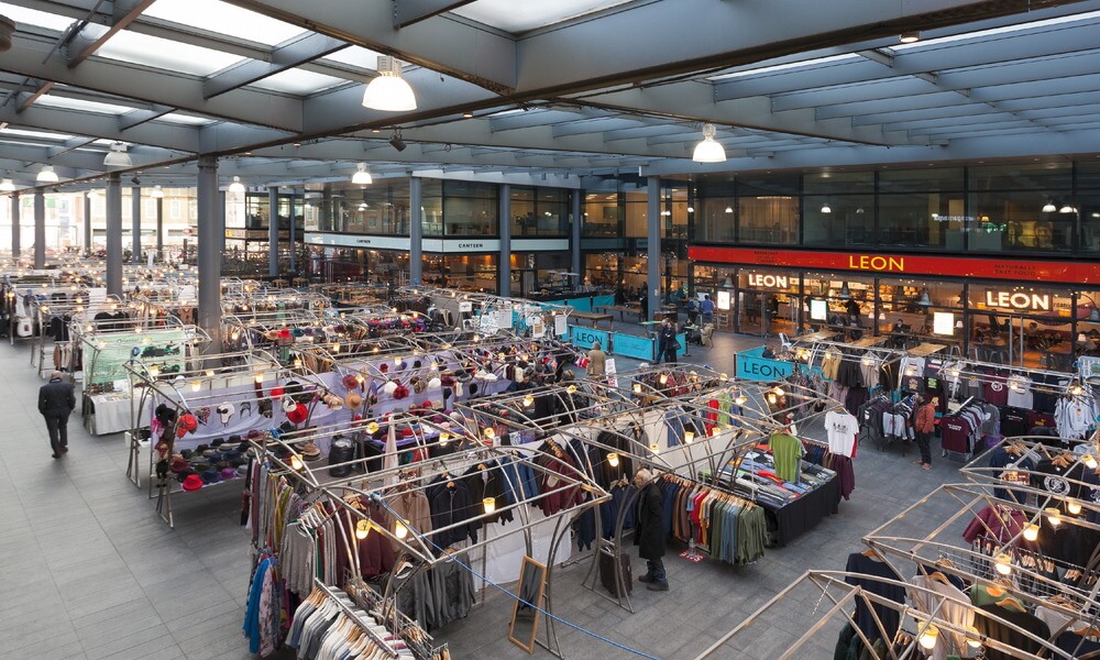 A large indoor market with lots of clothes on display.