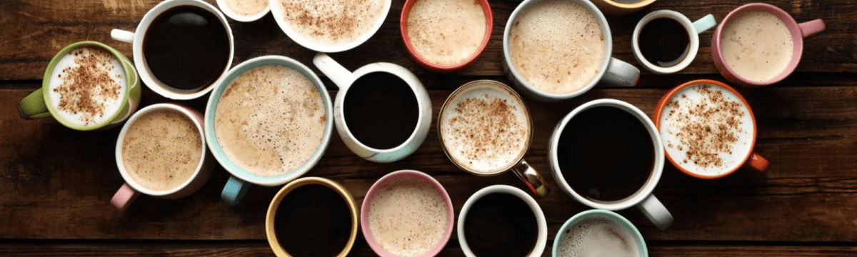 Many cups of coffee are arranged in a circle on a wooden table.