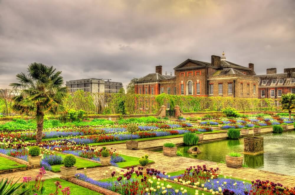 A garden with flowers and a castle in the background.