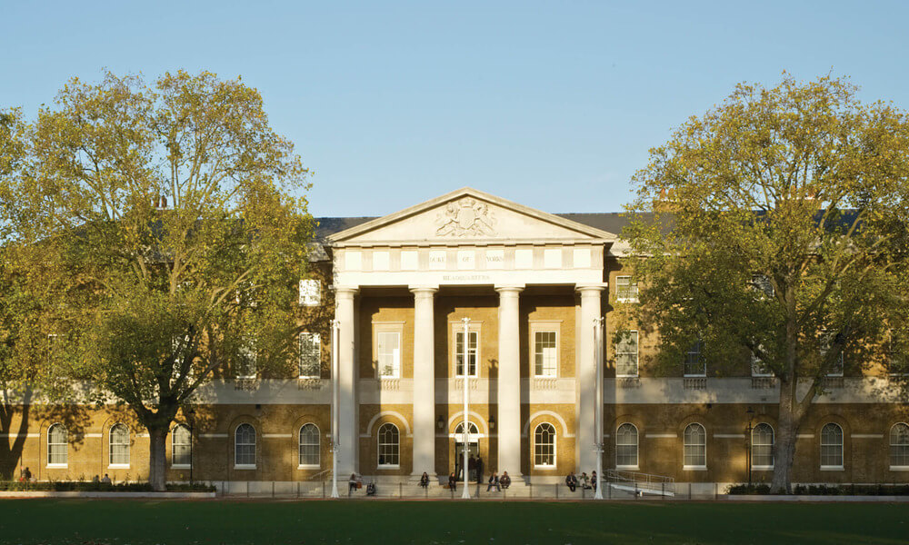 A large building with columns and trees in the background.