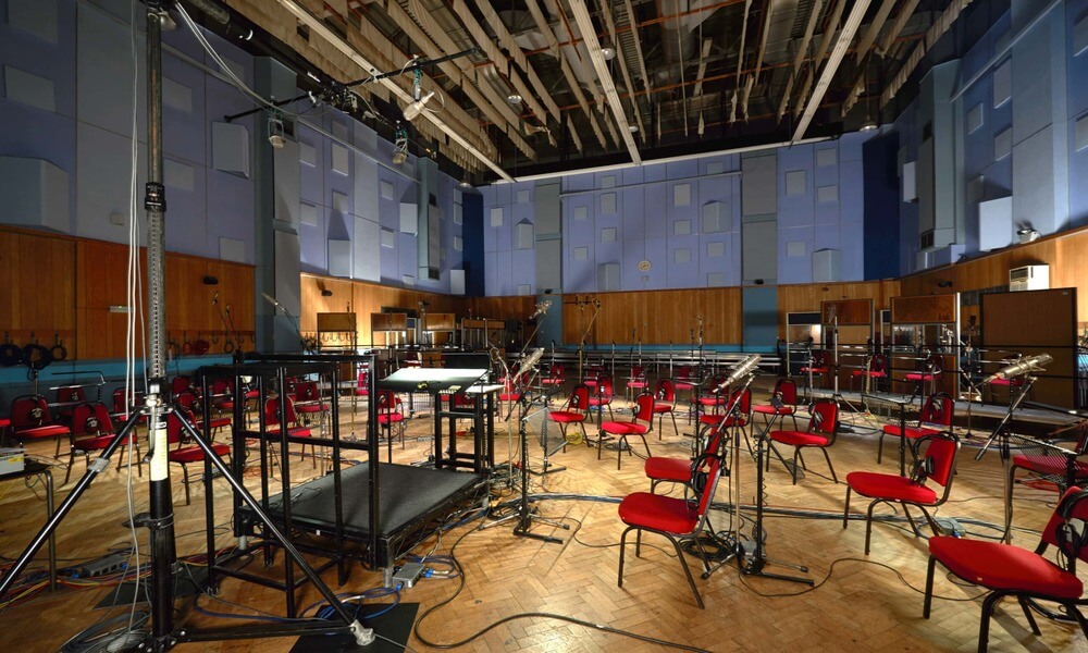A recording studio with red chairs and microphones.