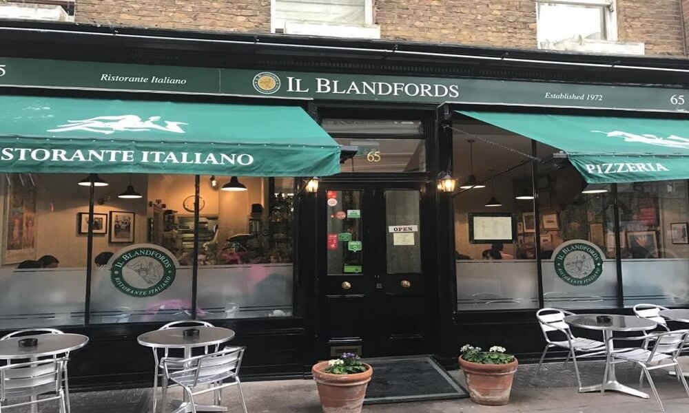A restaurant in london with green awnings.