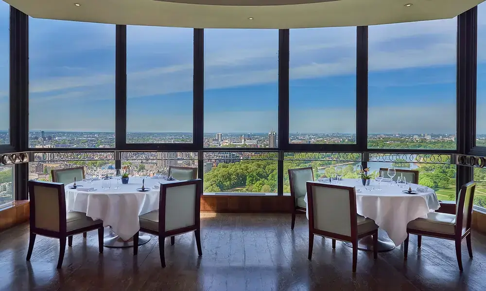 A restaurant with large windows overlooking a city.