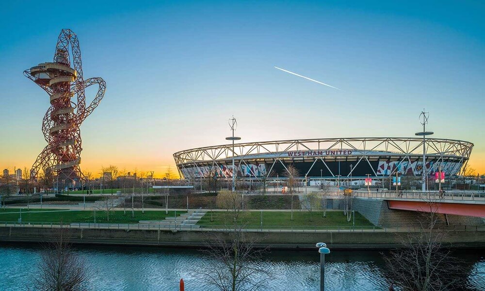 The olympic stadium in london at sunset.