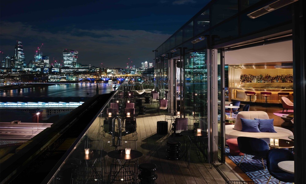 A view of london at night from a rooftop bar.