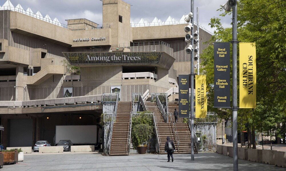 The entrance to a large building with yellow banners.