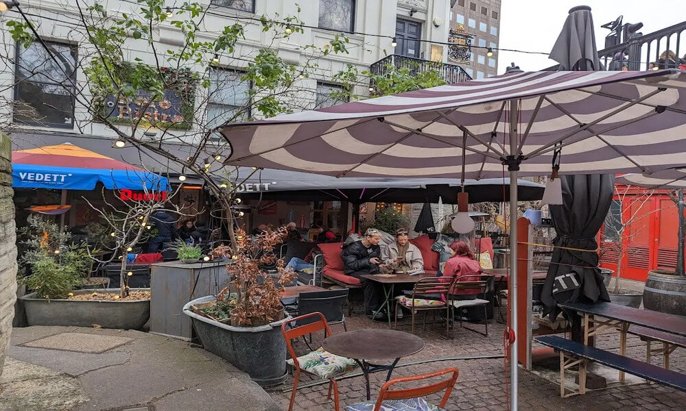 A group of people are sitting at tables in an outdoor area.