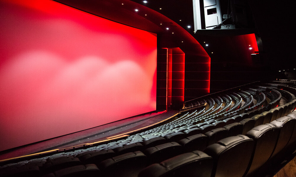 An empty auditorium with a red screen.