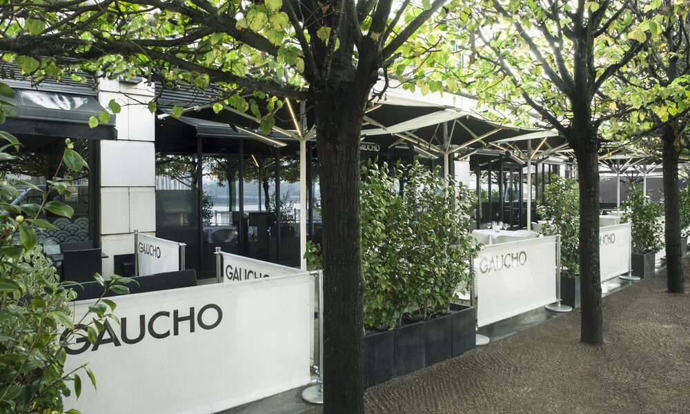 A restaurant with trees and a sign that says guacho.