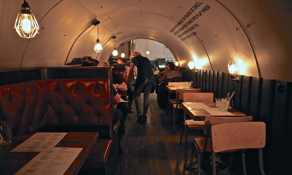 A restaurant with tables and chairs in a tunnel.