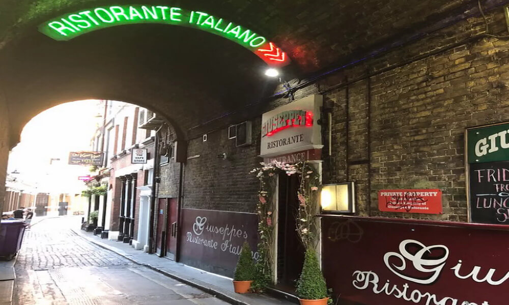 A tunnel with a sign for a restaurant in italy.