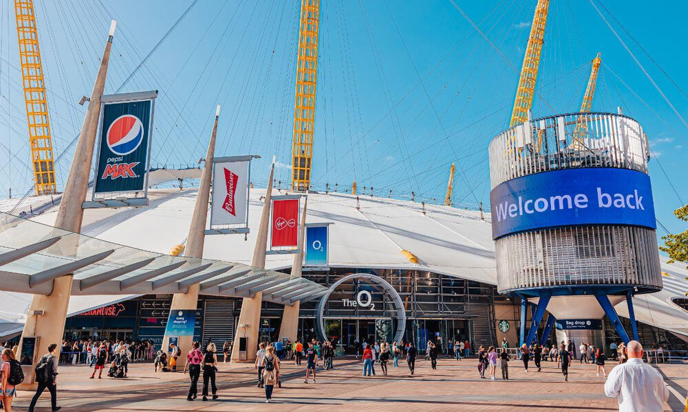 The o2 arena in london with people walking around.