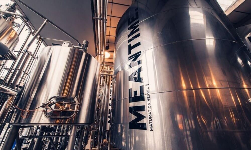 A brewery with a lot of stainless steel tanks.