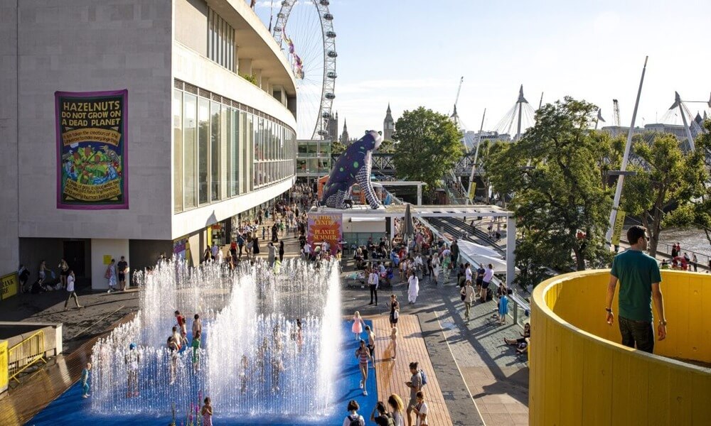 A group of people are playing in a water park near the london eye.