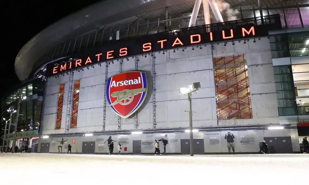 Emirates stadium at night with snow on the ground.