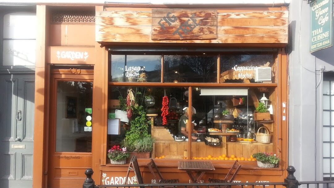The front of a coffee shop with a wooden table and chairs.