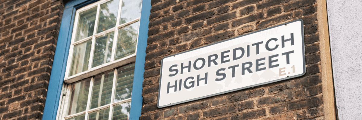 A sign that says shoreditch high street on the side of a brick building.