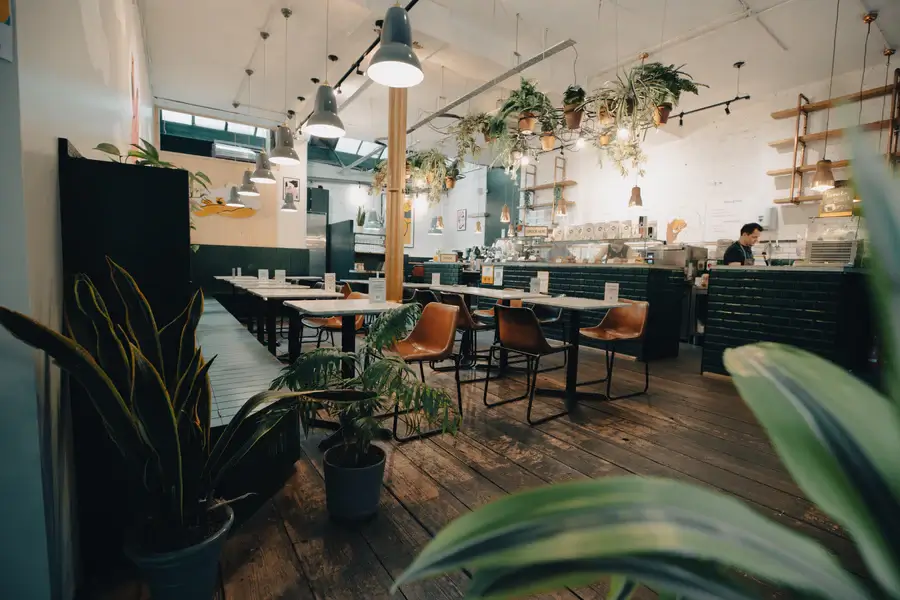The interior of a restaurant with a lot of plants.