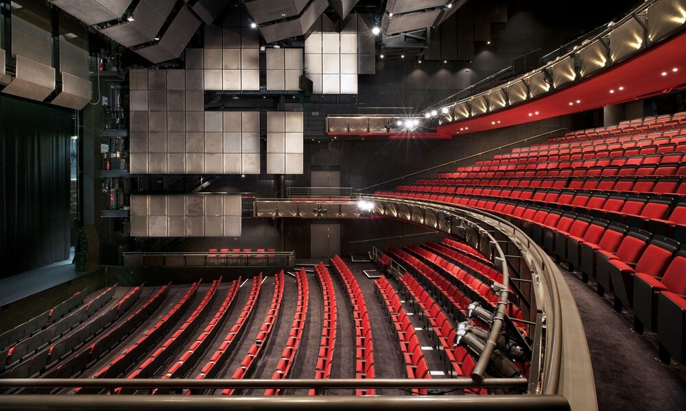 The interior of an auditorium with red seats.