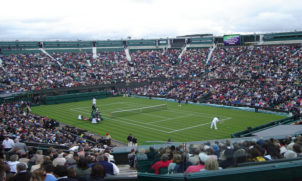 A crowd of people watching a tennis match.