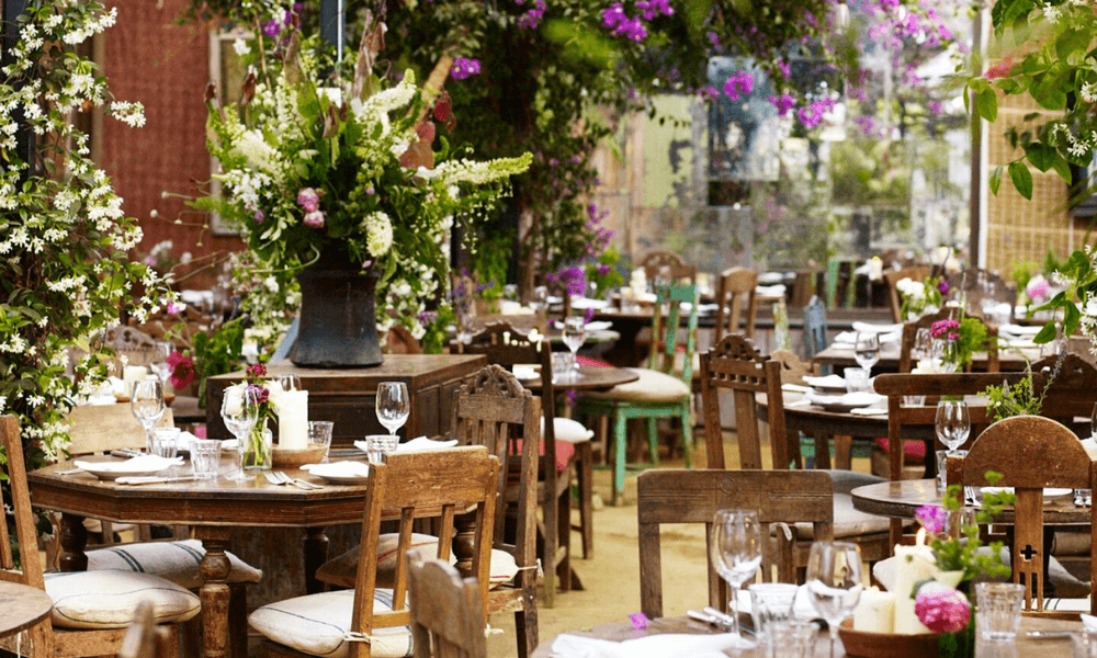 A restaurant with tables and chairs set up in a garden.