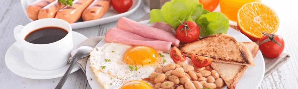 A plate with eggs, sausages, beans and coffee.