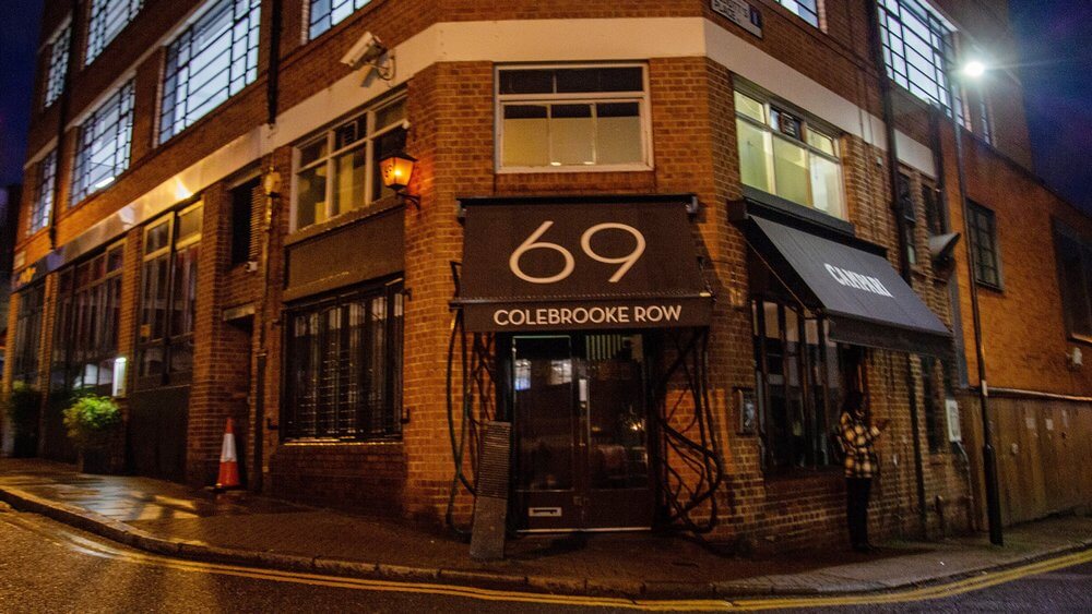 A building with the number 69 on it at night.