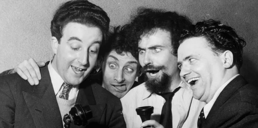 Three men with beards are holding microphones.