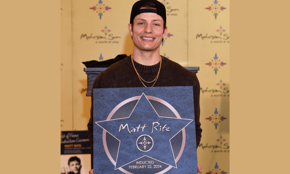 A man holding up a star with a hat on.