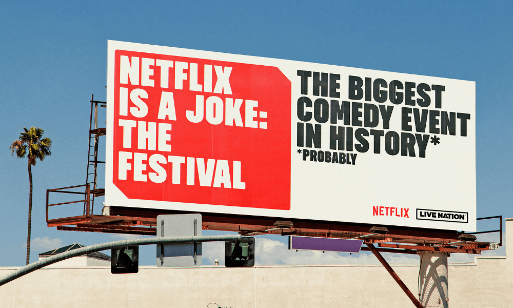 A billboard advertising netflix is a joke comedy event the festival.