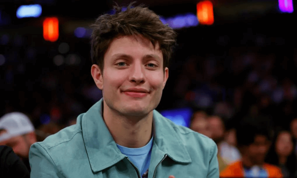 A young man smiling at a basketball game.