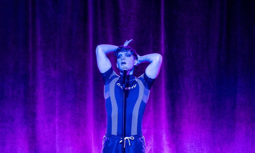 Performer on stage under blue lighting.