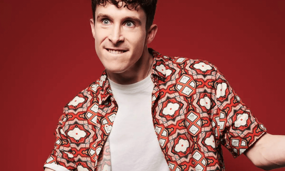 A man in a patterned shirt is posing for a photo.
