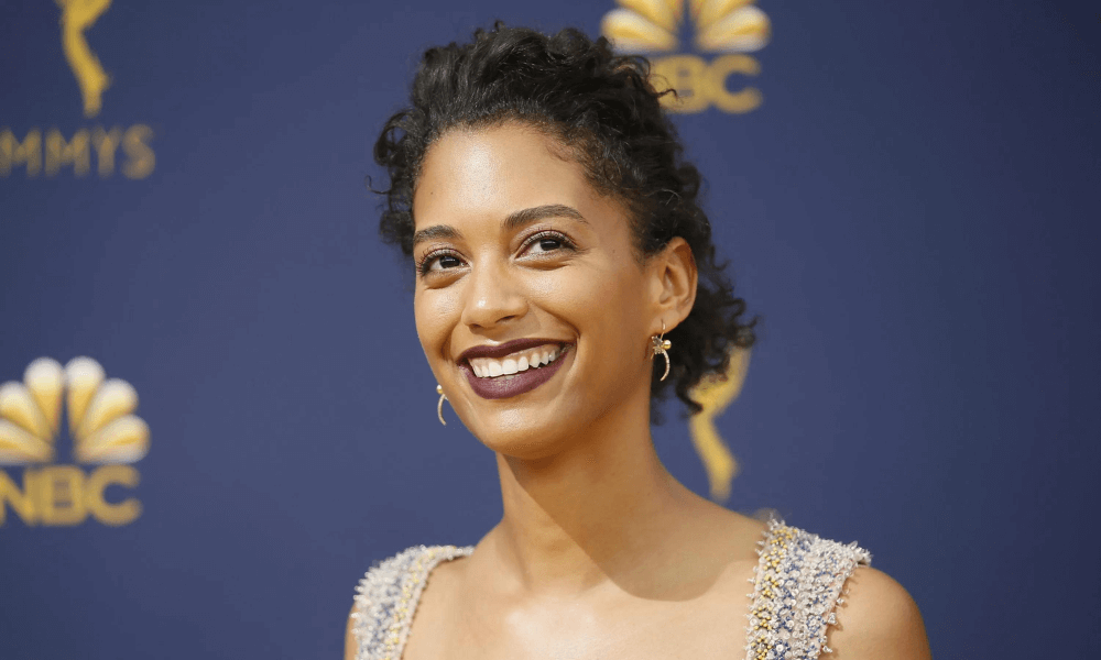 Woman with curly hair smiling at the emmys red carpet event.